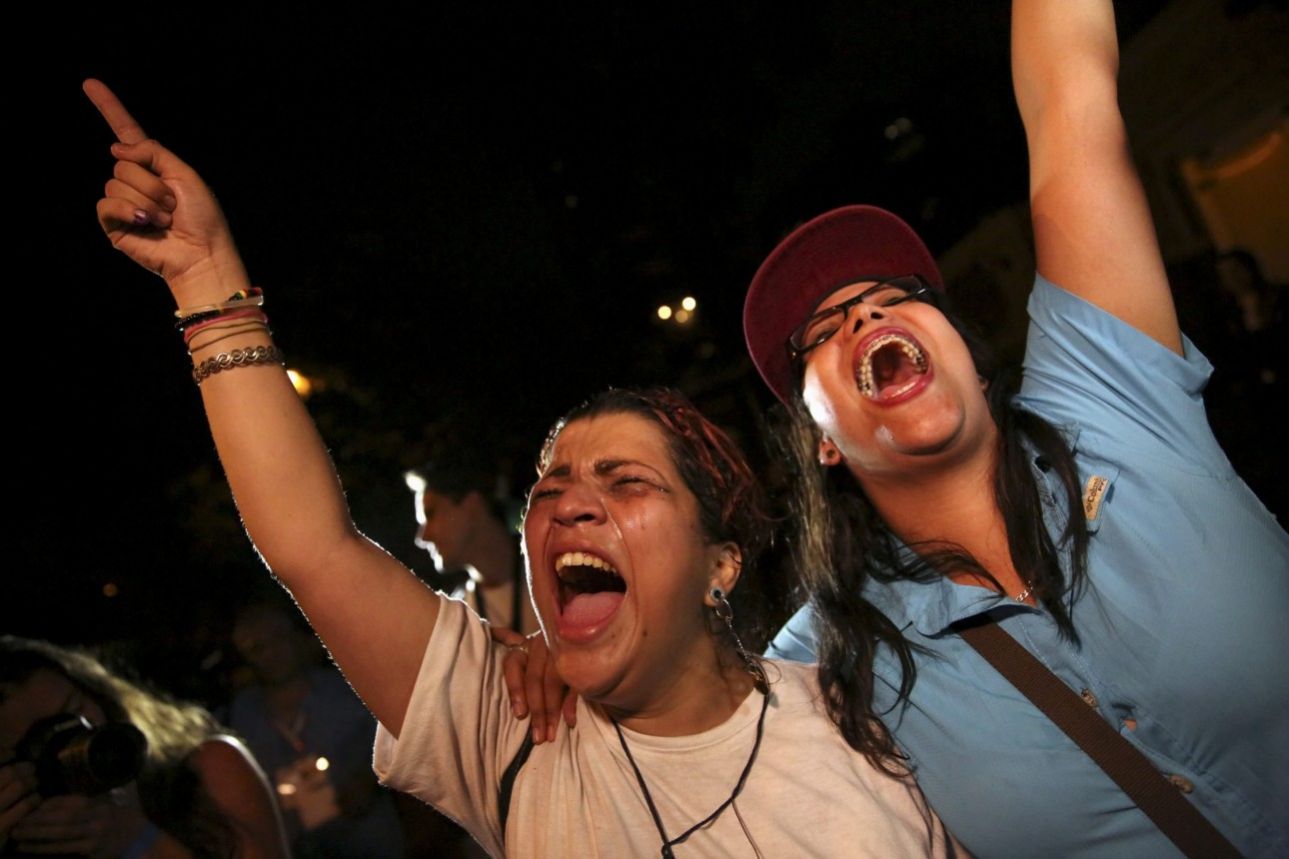 REFILE - ADDING NAME OF OPPOSITION Supporters of the opposition Democratic Unity coalition shout while they celebrate their victory on a street in Caracas December 7, 2015. Venezuela's opposition won control of the legislature from the ruling Socialists for the first time in 16 years on Sunday, giving them a long-sought platform to challenge President Nicolas Maduro. REUTERS/Nacho Doce