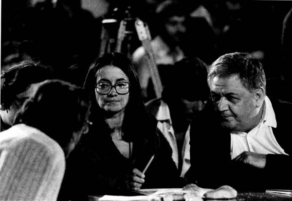 Η Ελένη Καραΐνδρου και ο Μάνος Χατζιδάκις με προσήλωση παρακολουθούν τον συνομιλητή τους Γιώργο Δεληγιαννάκη, διευθυντή της Μουσικής Ακαδημίας Ηρακλείου, την οποία είχε συστήσει ο Μάνος. Το στιγμιότυπο είναι φυσικά από τα Ανώγεια και τις εκδηλώσεις που διοργάνωνε στα ψηλώματα του Ψηλορείτη ο Μάνος για λογαριασμό του Τρίτου Προγράμματος. 