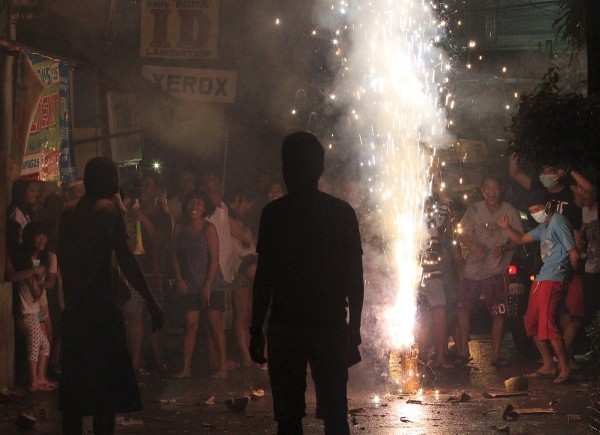 Revelers dance in front of lit sparklers while celebrating New Year's Eve in Paranaque city, metro Manila December 31, 2015. REUTERS/Romeo Ranoco