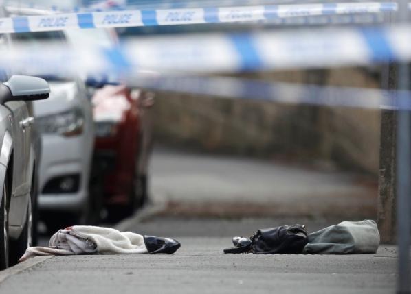Women's shoes and a handbag lie on the ground behind a police cordon in Birstall near Leeds