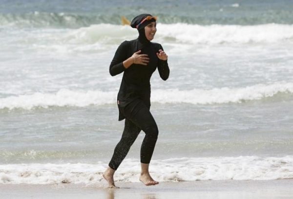 Volunteer surf life saver trainee Mecca Laalaa runs along North Cronulla Beach in Sydney wearing a burkini, January 13, 2007. REUTERS/Tim Wimborne