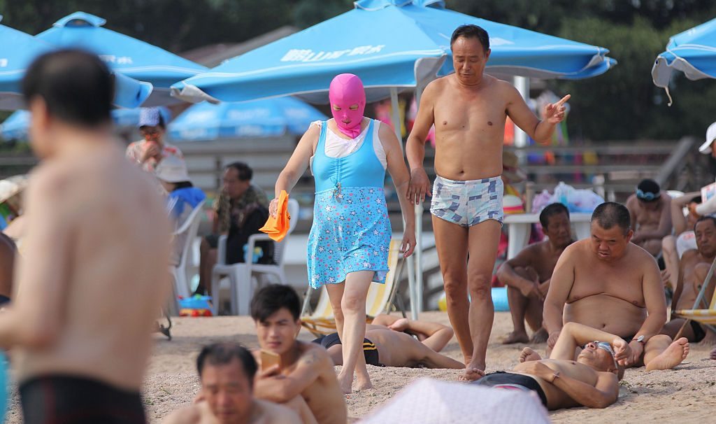 QINGDAO, CHINA - AUGUST 22: A woman wearing a facekini walks on beach on August 22, 2016 in Qingdao, Shandong Province of China. People wear facekinis to protect themselves from sun's rays, jellyfish and algae. (Photo by Huang Jiexian/VCG via Getty Images)
