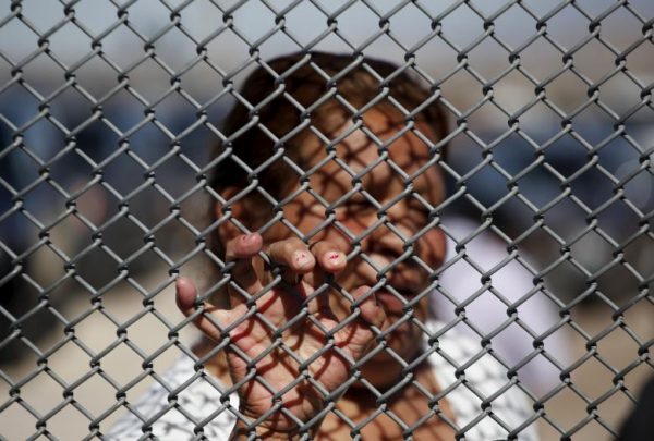 A Mexican migrant talks to a family member through the border fence between Ciudad Juarez and El Paso, United States, after a bi-national Mass in support of migrants in Ciudad Juarez, Mexico, February 15, 2016. REUTERS/Jose Luis Gonzalez
