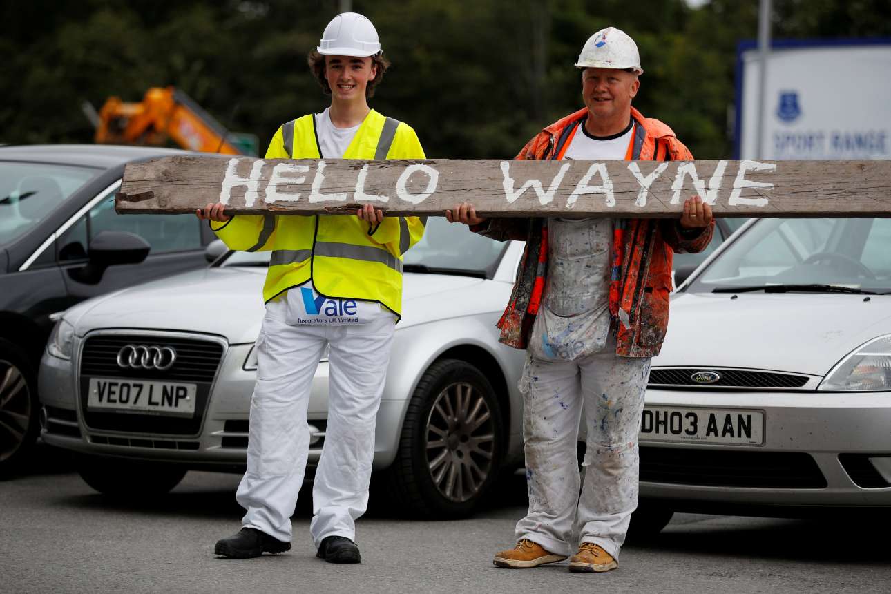 Δύο εργάτες στο Λίβερπουλ, οπαδοί της Εβερτον, καλωσορίζουν τον Ρούνεϊ (REUTERS)