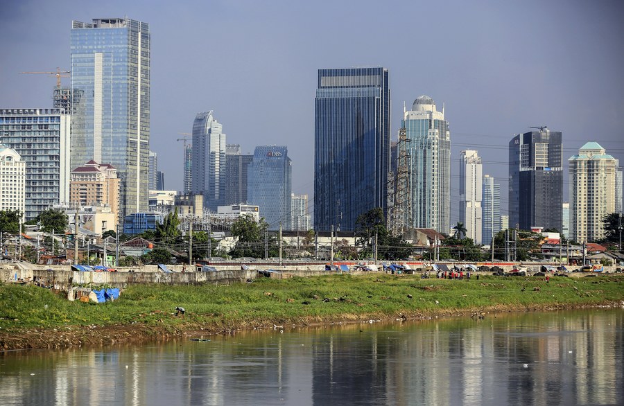 epa05926601 High-rise buildings are seen near shacks on the edge of a river bank, in Jakarta, Indonesia, 25 April 2017. According to media reports, the Indonesian government has targeted the country's economic growth in 2017 to reach 5.1 percent. EPA/DEDI SINUHAJI