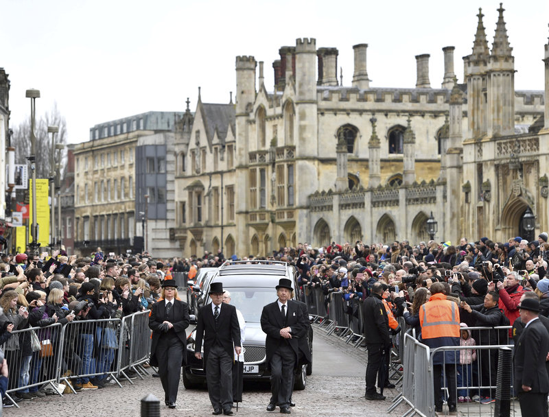 The hearse containing Professor Stephen Hawking arrives at University Church of St Mary the Great as mourners gather to pay their respects, in Cambridge, England, Saturday March 31, 2018. The renowned British physicist died peacefully on March 14 at the age of 76. (Joe Giddens/PA via AP)