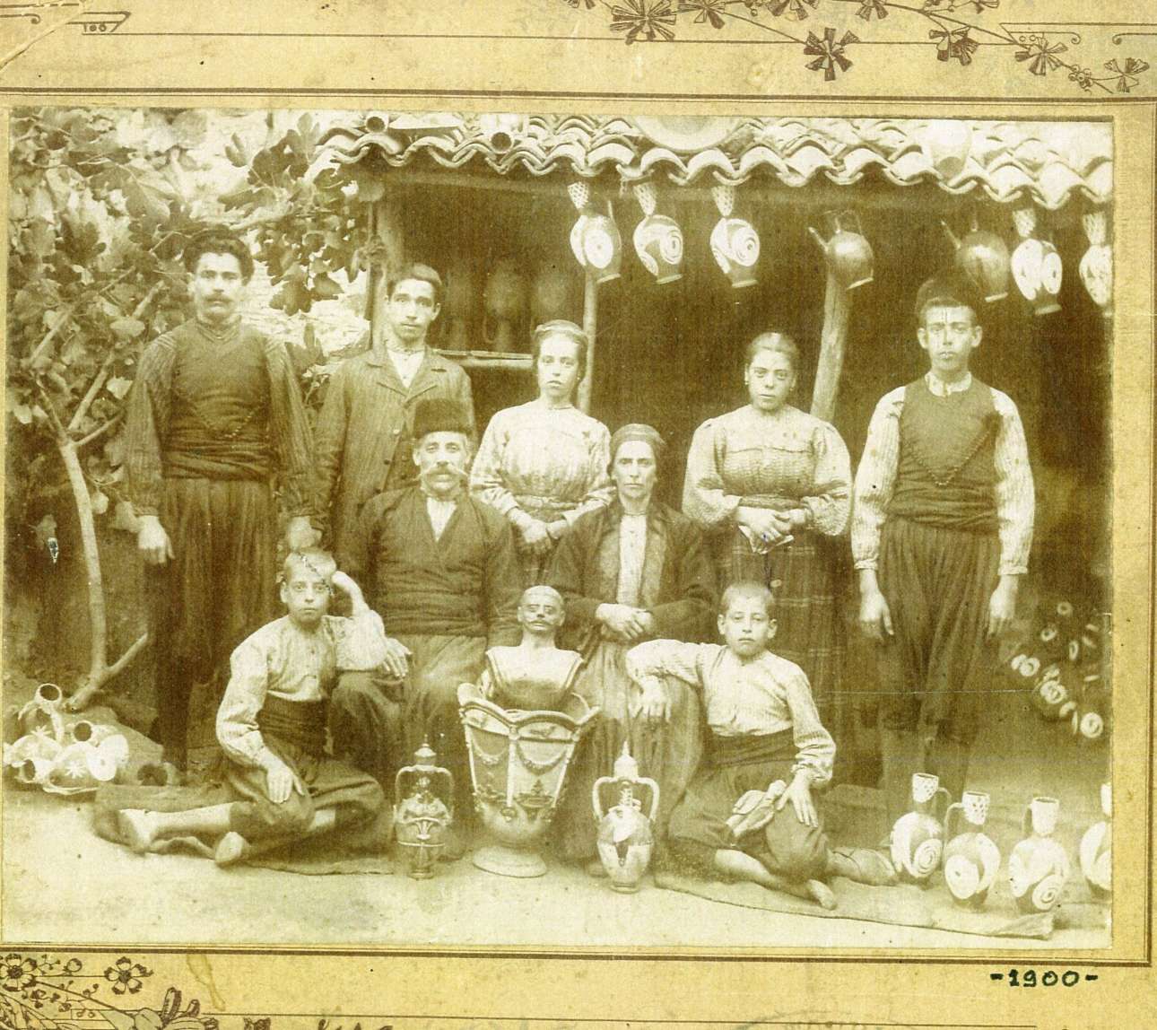 Το εργαστήριο του Νικόλα Κουρτζή του πρεσβύτερου, στις αρχές του 20ού αιώνα. Η  οικογένεια περιστοιχισμένη από δείγματα της δουλειάς της