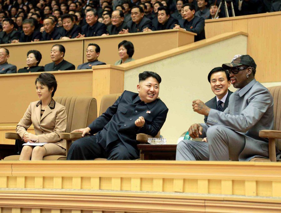 A picture released by the North Korean Central News Agency (KCNA) on 09 January 2014 shows North Korean leader Kim Jong-un (C), next to his wife Ri Sol-ju (L), talking to Dennis Rodman (R), retired Hall of Fame professional basketball player, while watching a friendly game between North Korean players and former NBA players at Pyongyang Indoor Stadium in Pyongyang, North Korea, 08 January 2014.