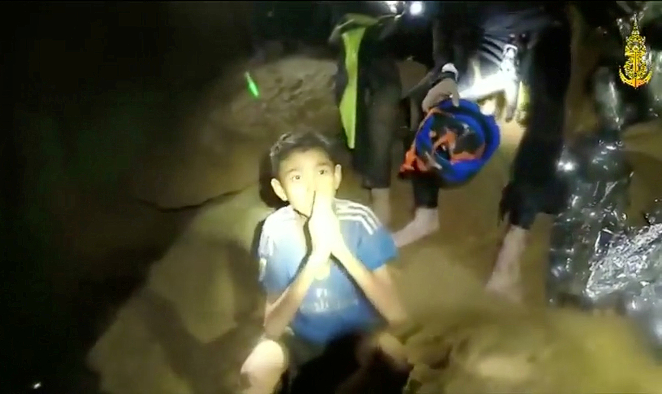 Boys from the under-16 soccer team trapped inside Tham Luang cave greet members of the Thai rescue team in Chiang Rai, Thailand, in this still image taken from a July 3, 2018 video by Thai Navy Seal. Thai Navy Seal/Handout via REUTERS TV ATTENTION EDITORS - THIS IMAGE WAS PROVIDED BY A THIRD PARTY. NO RESALES. NO ARCHIVE. MANDATORY CREDIT.