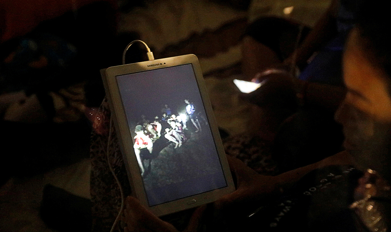 A family member looks at a photo near Tham Luang cave complex, as members of under-16 soccer team and their coach have been found alive according to a local media's report in the northern province of Chiang Rai, Thailand, July 2, 2018. REUTERS/Soe Zeya Tun