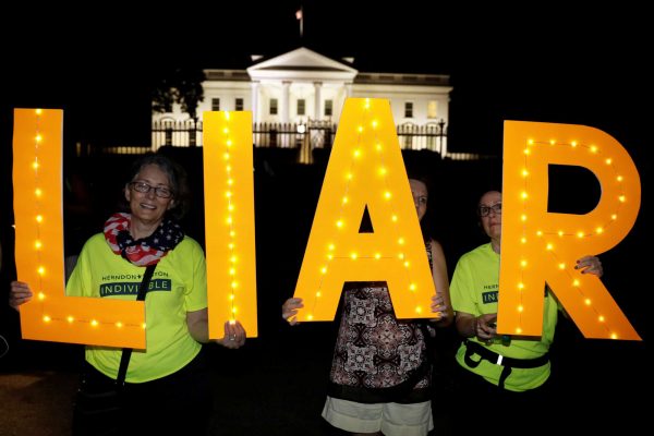 Διαμαρτυρόμενοι έξω από τον Λευκό Οίκο με... φωτεινές επιγραφές που γράφουν «Liar» Ψεύτη») φωτό: REUTERS/Kevin Lamarque)